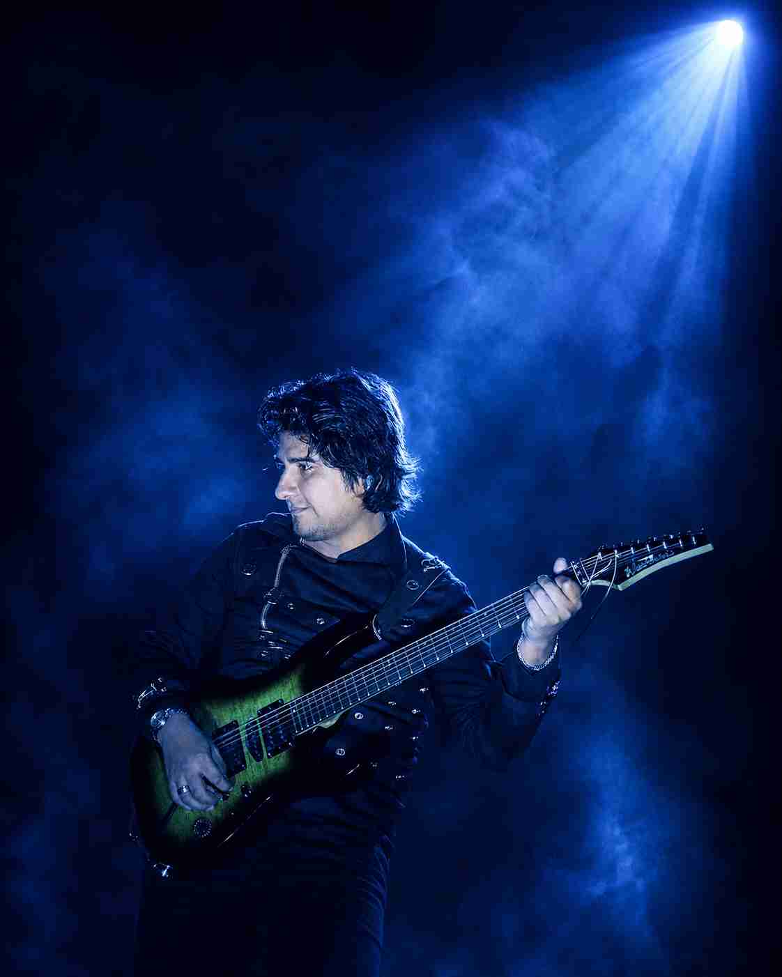 Val Staccato cinematic instrumental rock guitarist performing on a blue stage in Lima Peru